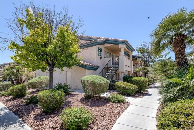 8410 Eldora Ave Unit 1045, Las Vegas, NV 89117 - view of side of property featuring stairs, a tiled roof, and stucco siding