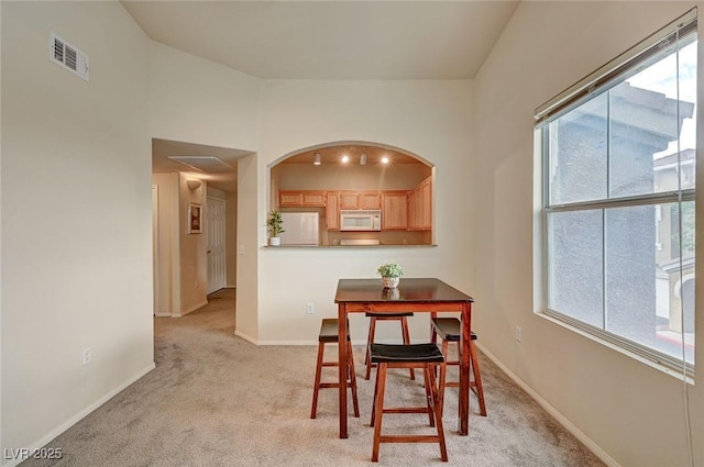 dining space featuring light carpet, baseboards, and visible vents