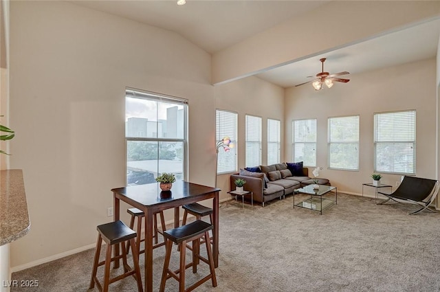 living area with carpet, vaulted ceiling, baseboards, and ceiling fan