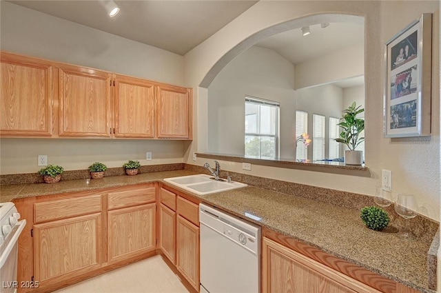 kitchen featuring white dishwasher, light brown cabinets, range, a sink, and arched walkways