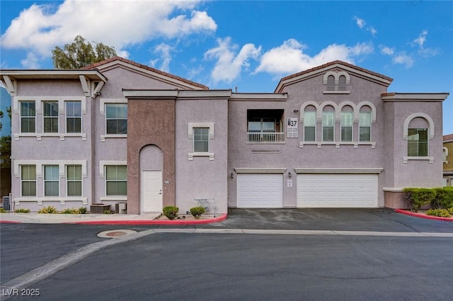 view of front of property featuring an attached garage, stucco siding, and aphalt driveway