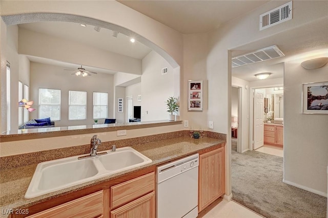 kitchen with a sink, open floor plan, visible vents, light carpet, and white dishwasher
