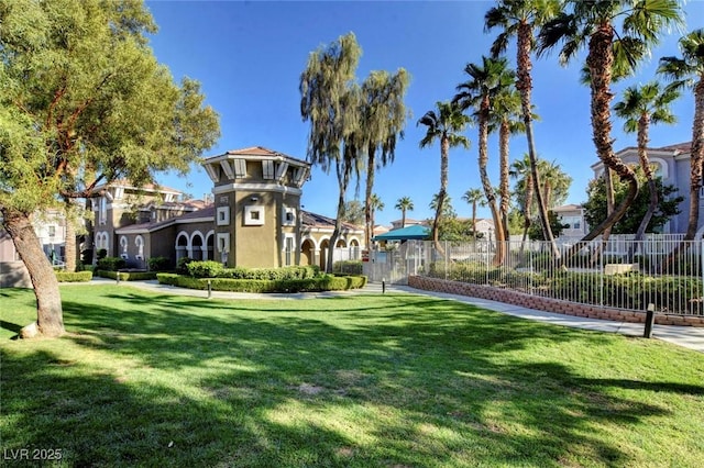 view of property's community featuring fence and a lawn