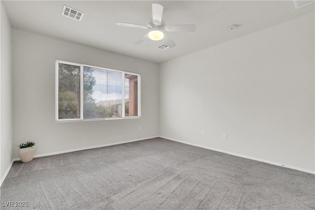 carpeted spare room with visible vents, baseboards, and a ceiling fan