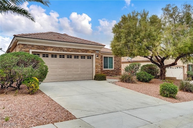 view of front of house with an attached garage, stucco siding, a tile roof, concrete driveway, and stone siding