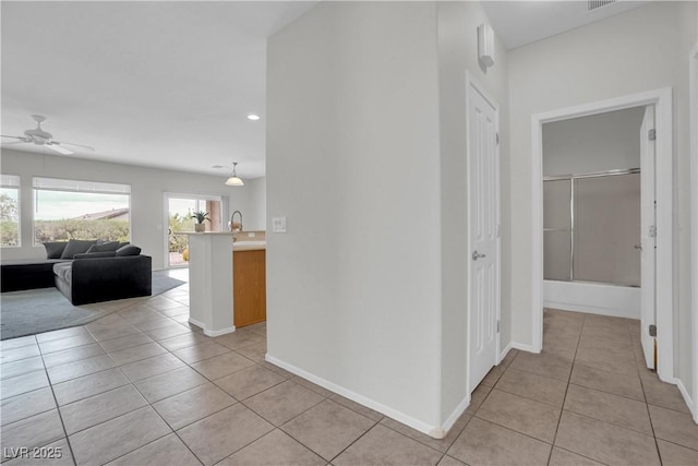 corridor with light tile patterned floors, baseboards, and recessed lighting