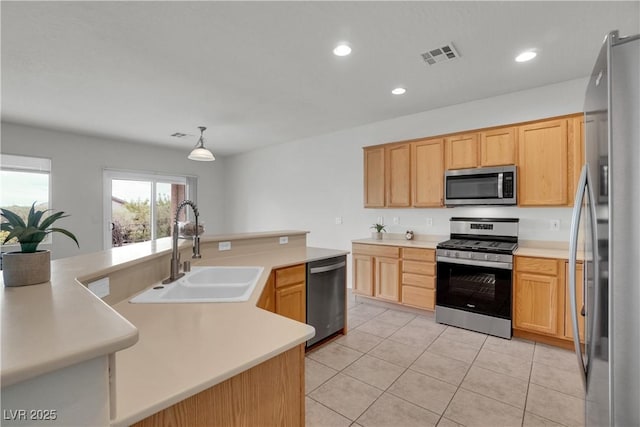 kitchen with light tile patterned floors, a sink, stainless steel appliances, visible vents, and light countertops