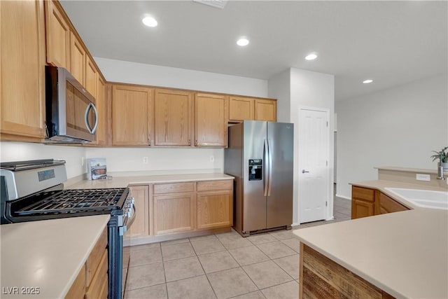 kitchen featuring light tile patterned floors, a sink, stainless steel appliances, light countertops, and recessed lighting