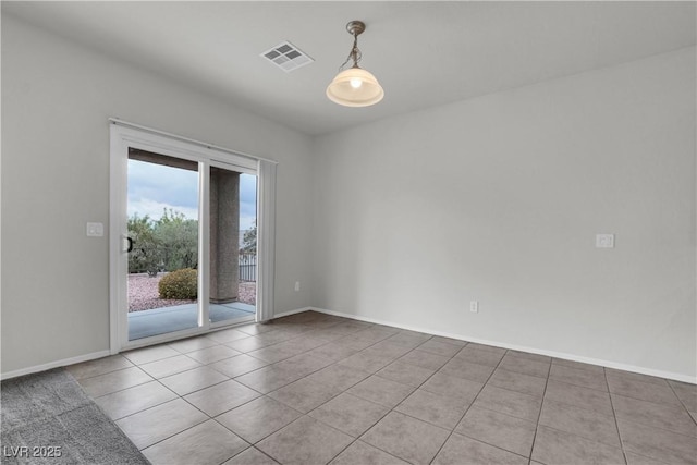 spare room featuring tile patterned floors, visible vents, and baseboards
