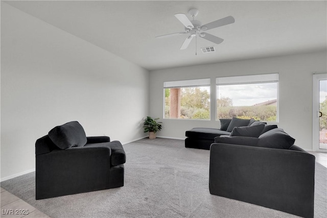 carpeted living room with ceiling fan, baseboards, and visible vents