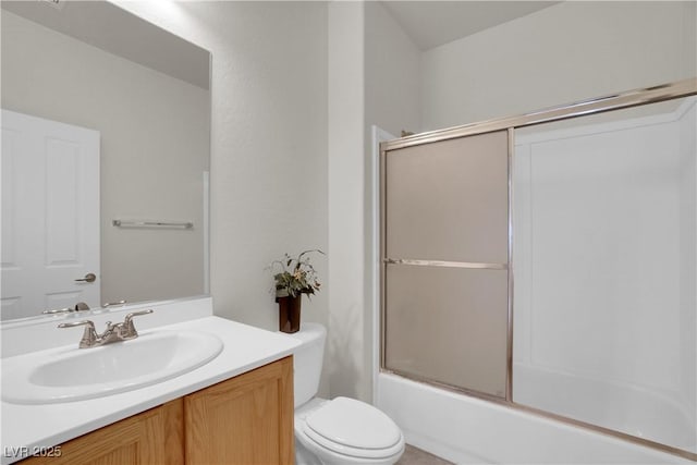 full bath featuring vanity, toilet, and bath / shower combo with glass door