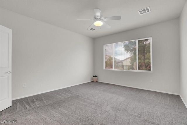 spare room featuring carpet flooring, visible vents, baseboards, and a ceiling fan