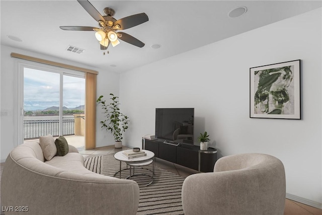 living area featuring a ceiling fan and baseboards