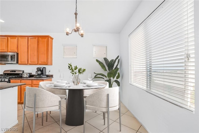 dining space featuring healthy amount of natural light, a chandelier, and light tile patterned floors