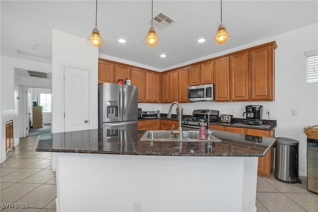 kitchen with appliances with stainless steel finishes, a sink, light tile patterned flooring, recessed lighting, and an island with sink