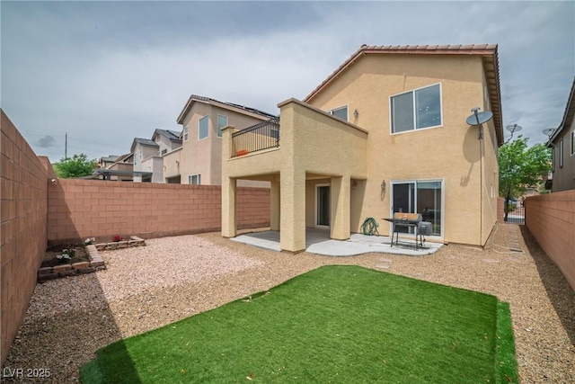 back of property featuring a balcony, stucco siding, and a patio