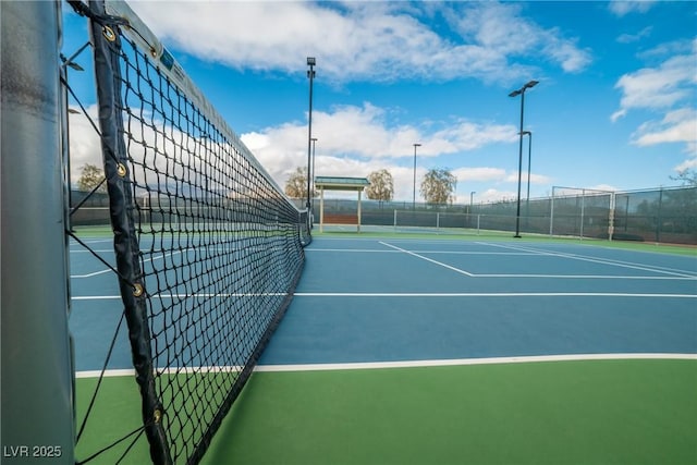 view of tennis court featuring fence