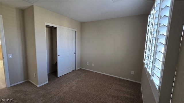 unfurnished bedroom with carpet floors, a closet, and baseboards