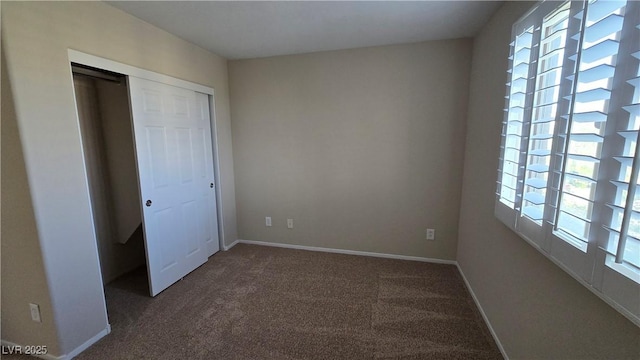 unfurnished bedroom featuring carpet floors, a closet, and baseboards