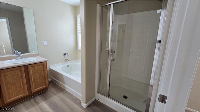 full bathroom with a bath, vanity, wood finished floors, and a shower stall