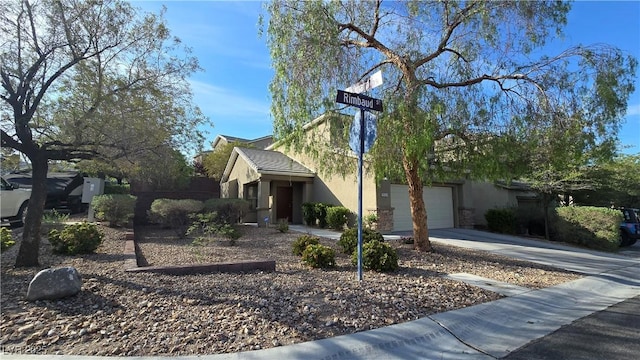 view of front of property featuring concrete driveway, stucco siding, and an attached garage