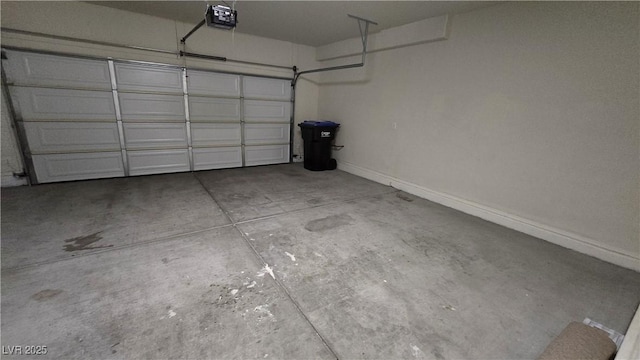 garage with baseboards and a garage door opener