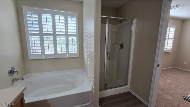 full bathroom featuring a bath, vanity, visible vents, and a stall shower
