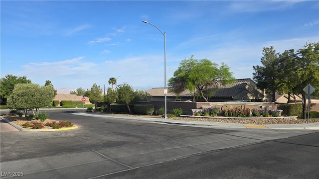 view of street with traffic signs, street lights, curbs, and sidewalks