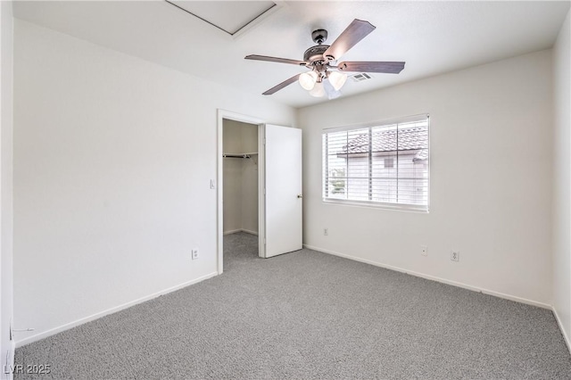 unfurnished bedroom featuring a spacious closet, carpet flooring, baseboards, and a closet