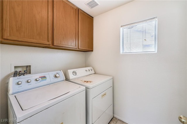 clothes washing area featuring cabinet space, washing machine and clothes dryer, and visible vents