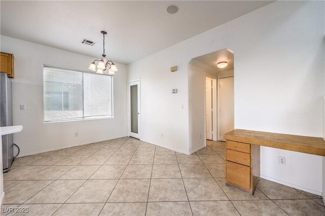 unfurnished dining area with baseboards, a notable chandelier, visible vents, and light tile patterned flooring