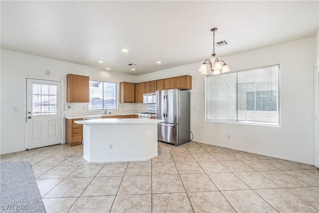 kitchen with white appliances, an inviting chandelier, visible vents, brown cabinets, and light countertops