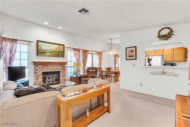 living area featuring light colored carpet, a ceiling fan, a fireplace, recessed lighting, and baseboards