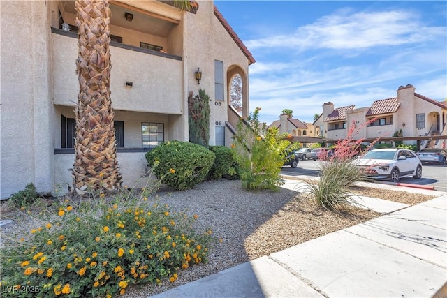 view of side of property with stucco siding, a residential view, and covered parking