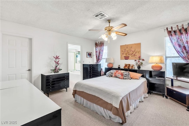 bedroom with light carpet, a textured ceiling, ceiling fan, and ensuite bathroom