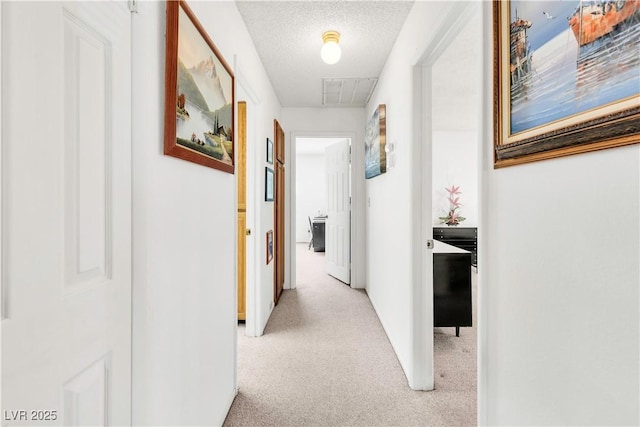 hall featuring light colored carpet and attic access