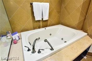 9101 Alta Dr Unit 507, Las Vegas, NV 89145 - bathroom with a whirlpool tub and tile walls