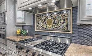 9101 Alta Dr Unit 507, Las Vegas, NV 89145 - kitchen featuring appliances with stainless steel finishes, wall chimney range hood, and light stone counters
