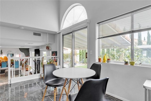 dining area featuring healthy amount of natural light and marble finish flooring