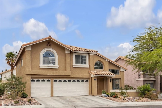 view of front of property with a garage, a tiled roof, driveway, and stucco siding