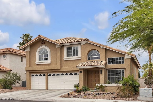mediterranean / spanish house featuring a garage, stucco siding, driveway, and a tile roof