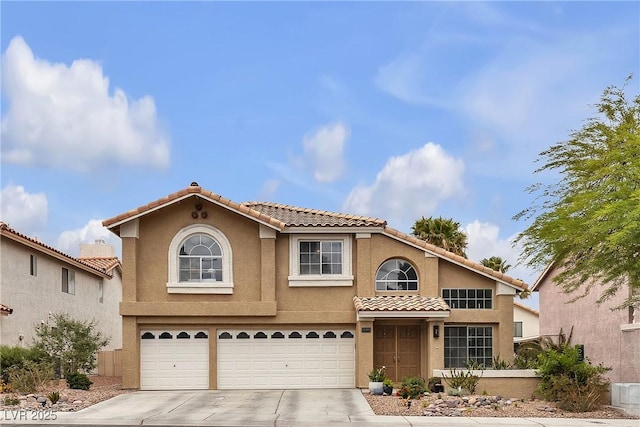 view of front of home featuring a garage, driveway, a tiled roof, and stucco siding