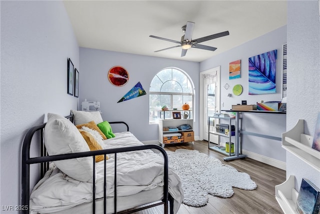 bedroom with wood finished floors, baseboards, and a ceiling fan