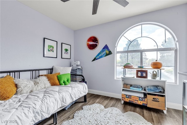 bedroom featuring wood finished floors, baseboards, and a ceiling fan