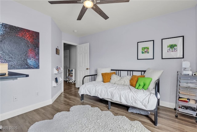 bedroom with wood finished floors, baseboards, and a ceiling fan