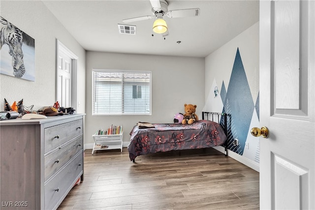 bedroom featuring wood finished floors, baseboards, and a ceiling fan