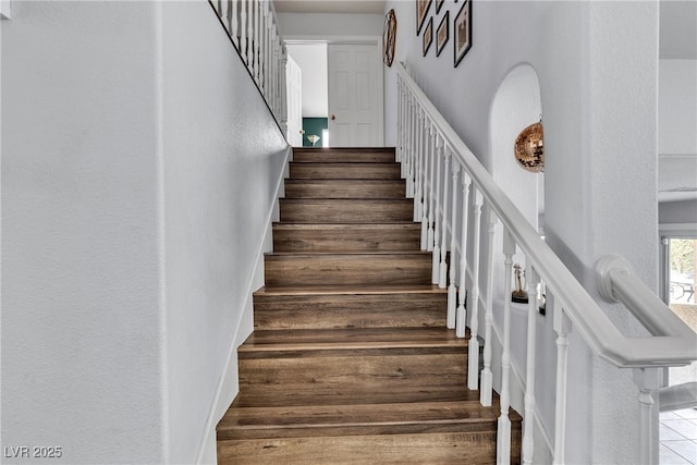 staircase featuring a textured wall