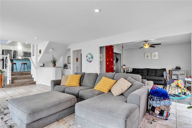 living area featuring light tile patterned flooring, a ceiling fan, stairs, and recessed lighting
