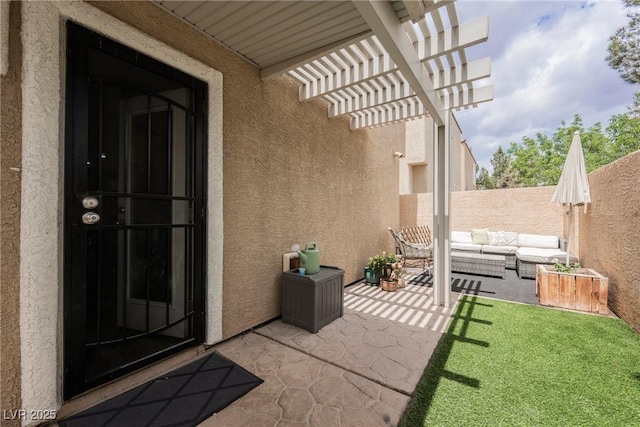 entrance to property featuring a patio, stucco siding, a pergola, fence, and an outdoor hangout area