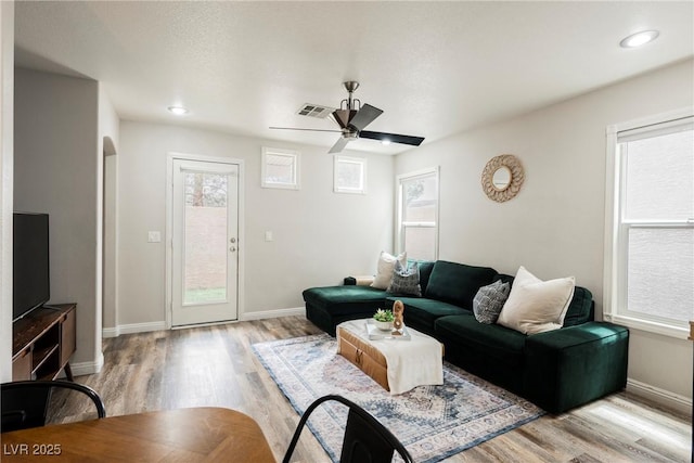 living room featuring light wood-type flooring, a ceiling fan, baseboards, and recessed lighting
